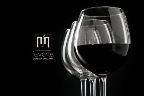 Calici di vino rosso su sfondo nero con logo Osteria Favorita – immagine simbolo della serata Vini Veri 2026